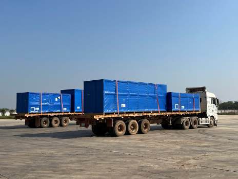 Flatbed truck carrying blue cargo crates, iSolution Logistics
